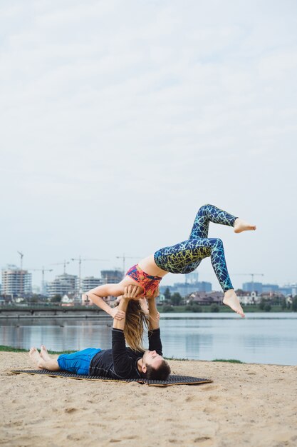 jong koppel beoefenen van yoga op stad achtergrond