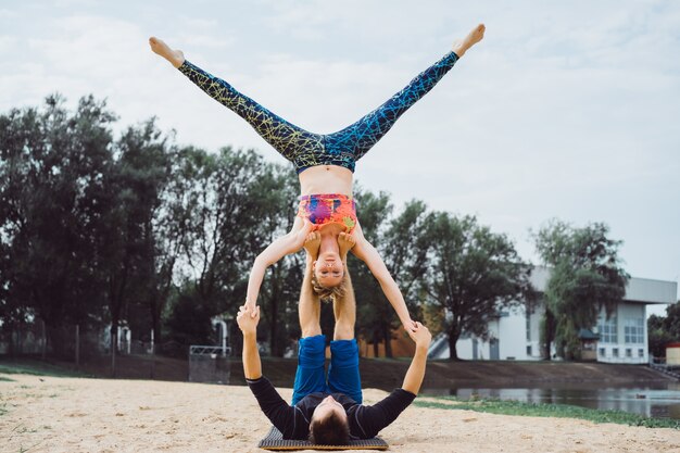 Gratis foto jong koppel beoefenen van yoga op stad achtergrond