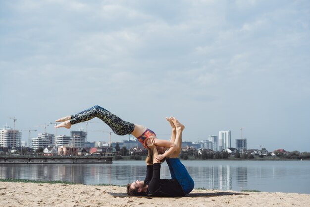 jong koppel beoefenen van yoga op stad achtergrond