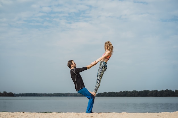 Jong koppel beoefenen van yoga op stad achtergrond