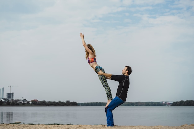 jong koppel beoefenen van yoga op stad achtergrond