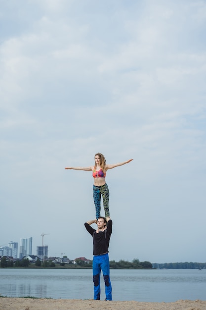 jong koppel beoefenen van yoga op stad achtergrond