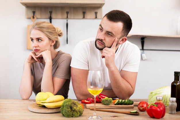 Gratis foto jong koppel dat bij de keuken denkt