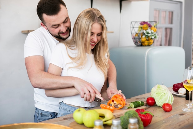 Gratis foto jong koppel dat de paprika snijdt