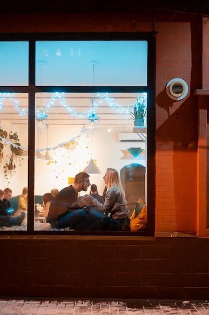 Gratis foto jong koppel in café met stijlvolle interieur