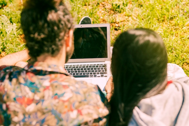 Gratis foto jong koppel met laptop in open plek