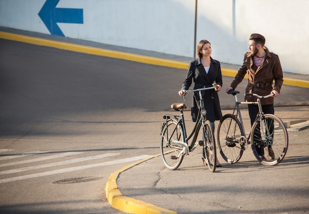 Jong koppel met op een fiets tegenover stad