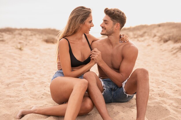 Jong koppel op het strand kijken naar elkaar