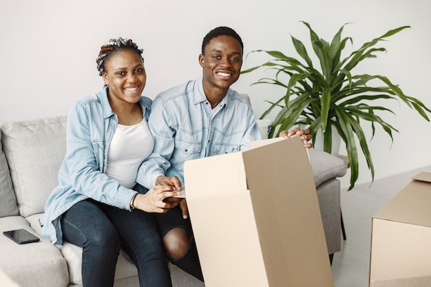 Jong koppel samen verhuizen naar nieuw huis. Afrikaans Amerikaans echtpaar met kartonnen dozen.