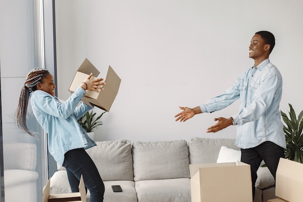 Gratis foto jong koppel samen verhuizen naar nieuw huis. afrikaans amerikaans echtpaar met kartonnen dozen.