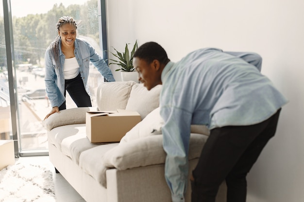 Gratis foto jong koppel samen verhuizen naar nieuw huis. afrikaans amerikaans echtpaar met kartonnen dozen.