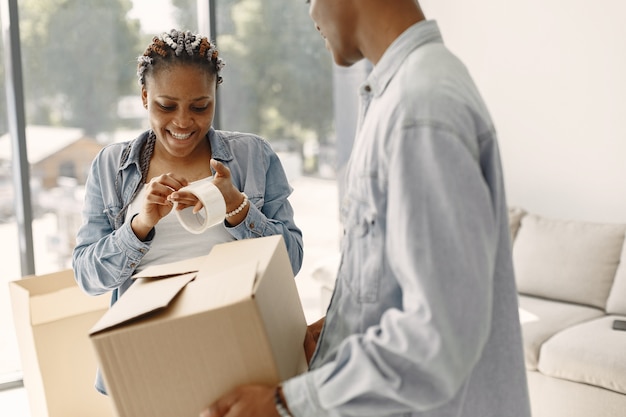 Jong koppel samen verhuizen naar nieuw huis. afrikaans amerikaans echtpaar met kartonnen dozen.