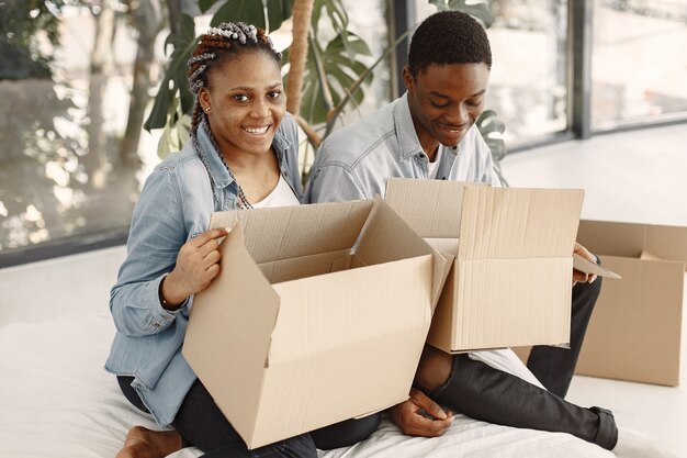Jong koppel samen verhuizen naar nieuw huis. Afrikaans Amerikaans echtpaar met kartonnen dozen.