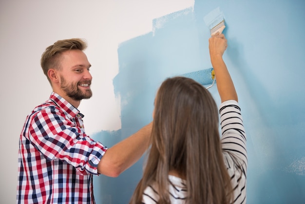 Jong koppel schilderen van een blauwe muur