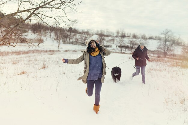 Jong koppel wandelen met een hond in een winterse dag