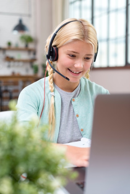 Jong leerlingsmeisje dat op laptop leert