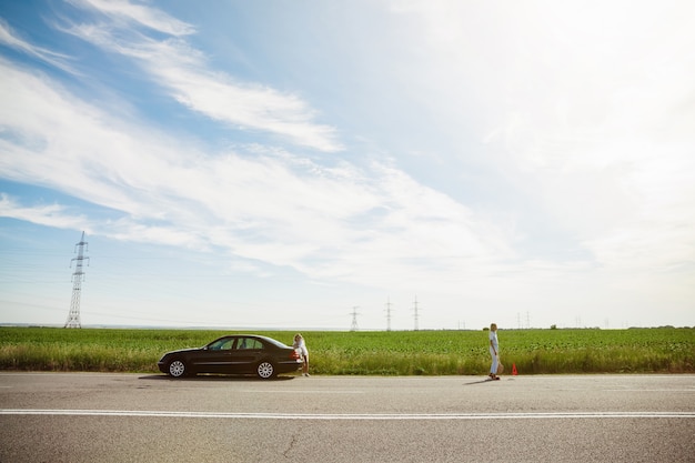 Jong lesbisch paar gaat op vakantie reis op de auto in zonnige dag