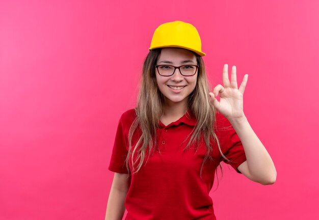 Jong leveringsmeisje in rood poloshirt en geel GLB dat in grote lijnen ok teken toont