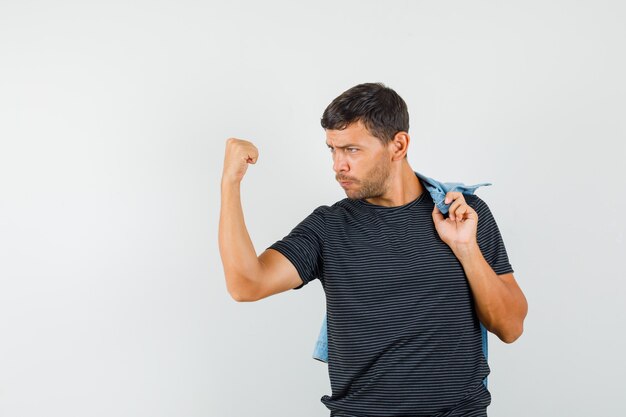 Jong mannetje dat winnaargebaar toont terwijl jasje in t-shirt wordt vastgehouden