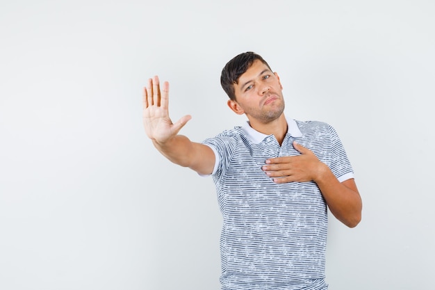 Jong mannetje in t-shirt die beleefd weigeringsgebaar tonen