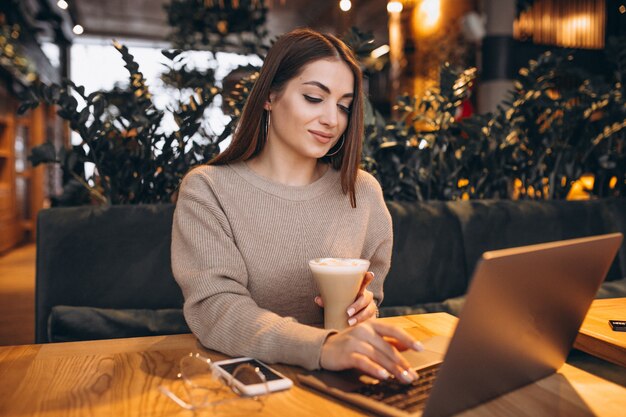Jong meisje dat aan een computer in een koffie werkt