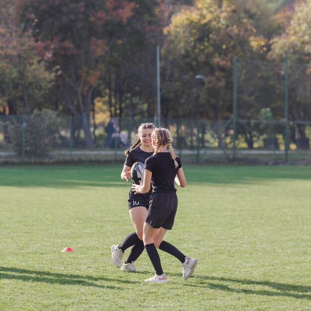 Jong meisje dat een rugbybal overgaat