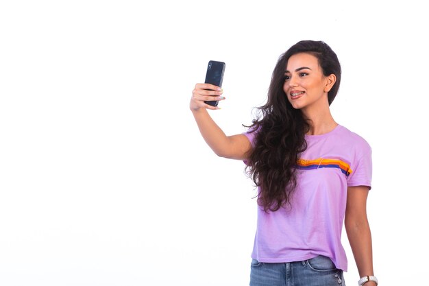 Jong meisje dat selfie neemt of een videogesprek voert.