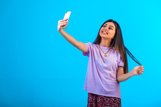 Jong meisje dat selfie op haar telefoon neemt.