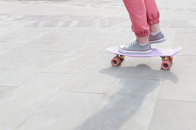 Jong meisje dat trucs met haar skateboardclose-up doet