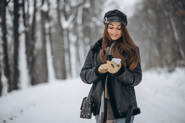 Jong meisje die op de telefoon in een de winterpark spreken