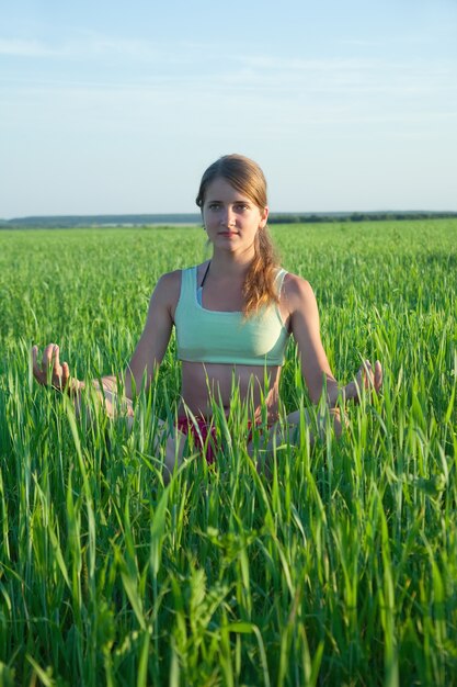 Jong meisje doet yoga tegen de natuur