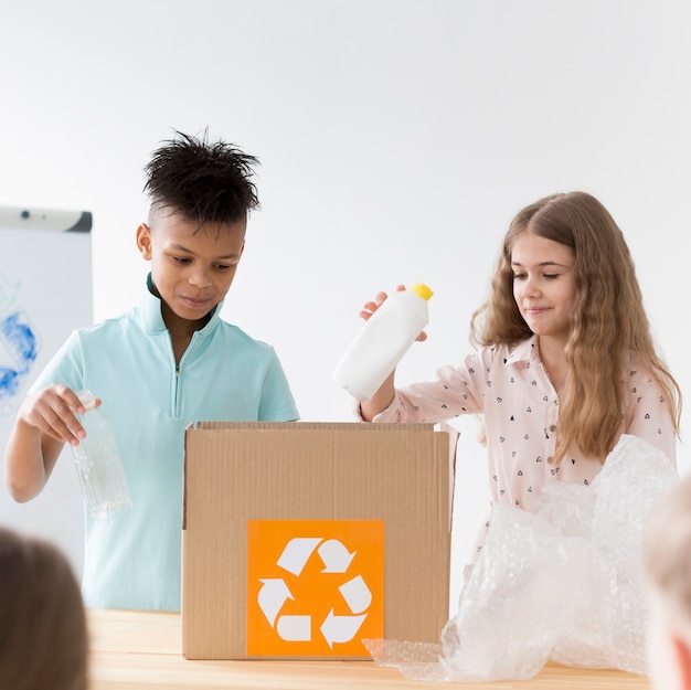 Gratis foto jong meisje en jongen leren hoe te recyclen