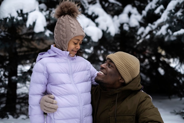 Jong meisje geniet van een winterdag buiten met haar vader