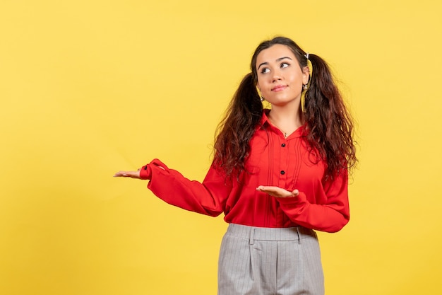 jong meisje in een rode blouse die zich voordeed op geel