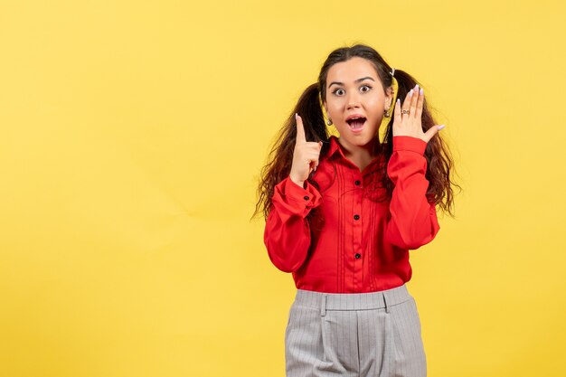 jong meisje in een rode blouse die zich voordeed op geel