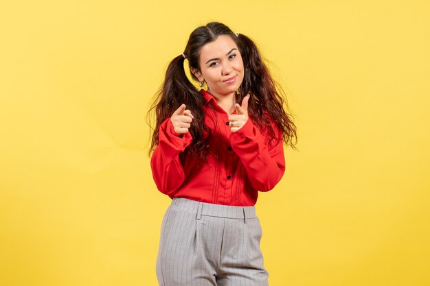 jong meisje in een rode blouse die zich voordeed op geel