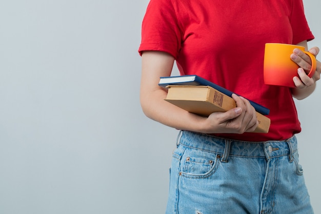 Jong meisje in rood shirt met een kopje drank