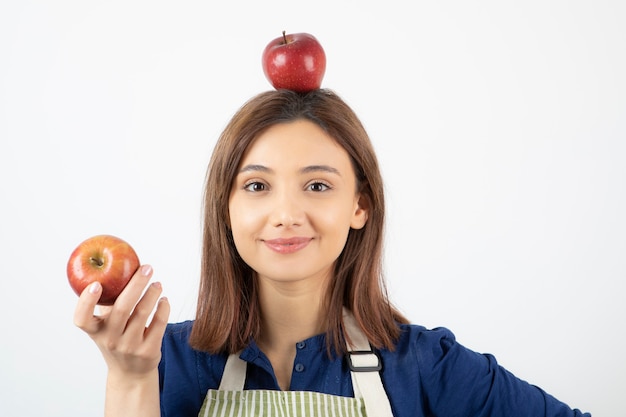 jong meisje met rode appels terwijl lachend op wit.