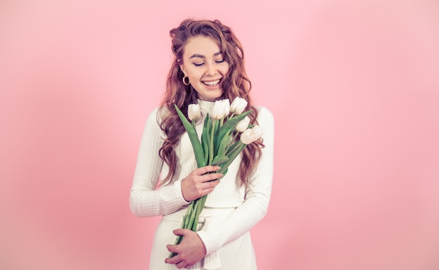 Jong meisje met tulpen op een gekleurde muur