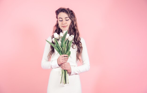 Jong meisje met tulpen op een gekleurde muur