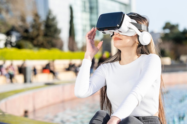 Jong meisje met vr-set en zittend in het park Hoge kwaliteit foto