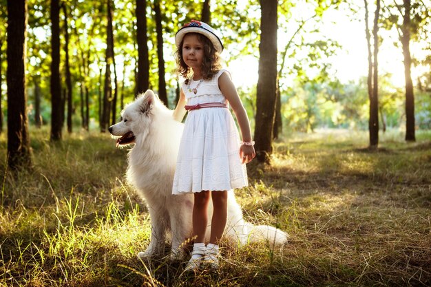 Jong meisje wandelen spelen met hond in park bij zonsondergang