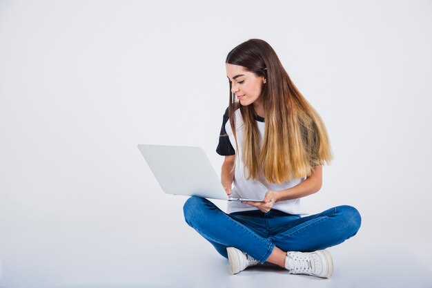 Jong meisje zittend op de vloer met lap top