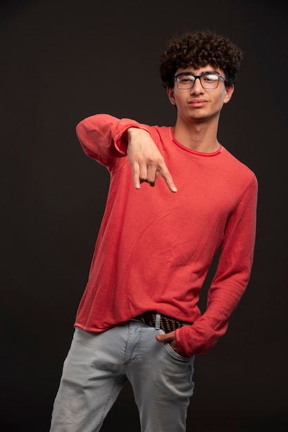 Jong model dat in rood overhemd vredesteken in gietstukken maakt.