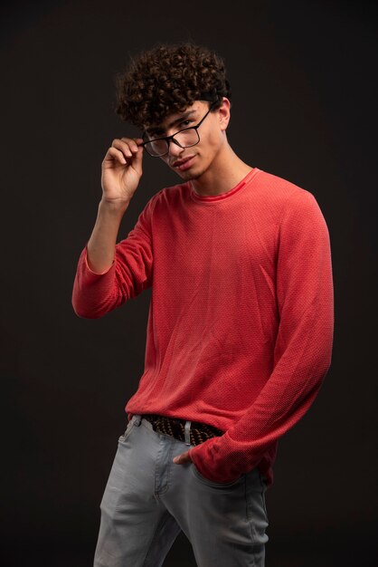 Jong model in rood overhemd dat oogglazen draagt.