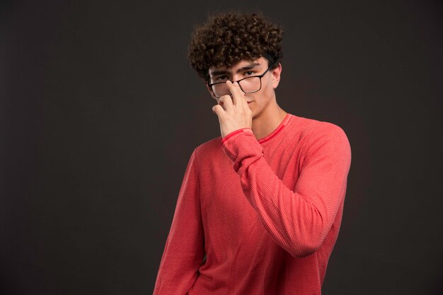 Jong model met krullende haren wat betreft zijn bril.