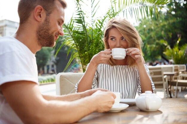 Jong mooi paar spreken, glimlachen, die in koffie rusten.