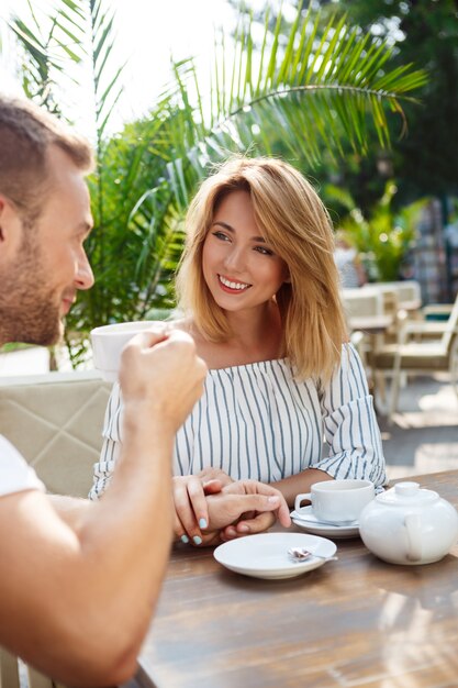 Jong mooi paar spreken, glimlachen, die in koffie rusten.