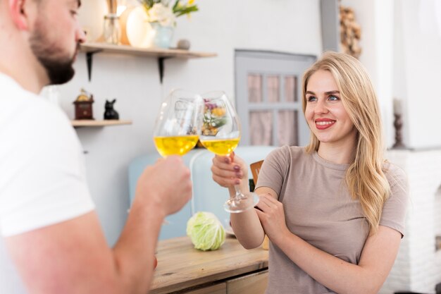 Jong paar dat omhoog met glazen toejuicht