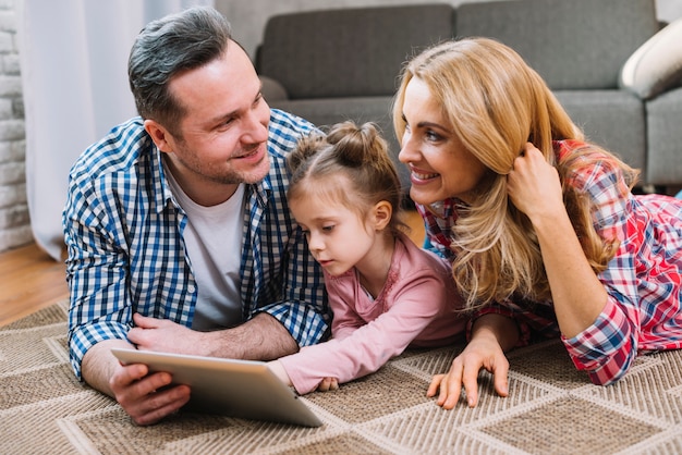 Jong paar die elkaar bekijken terwijl dochter die digitale tablet gebruiken